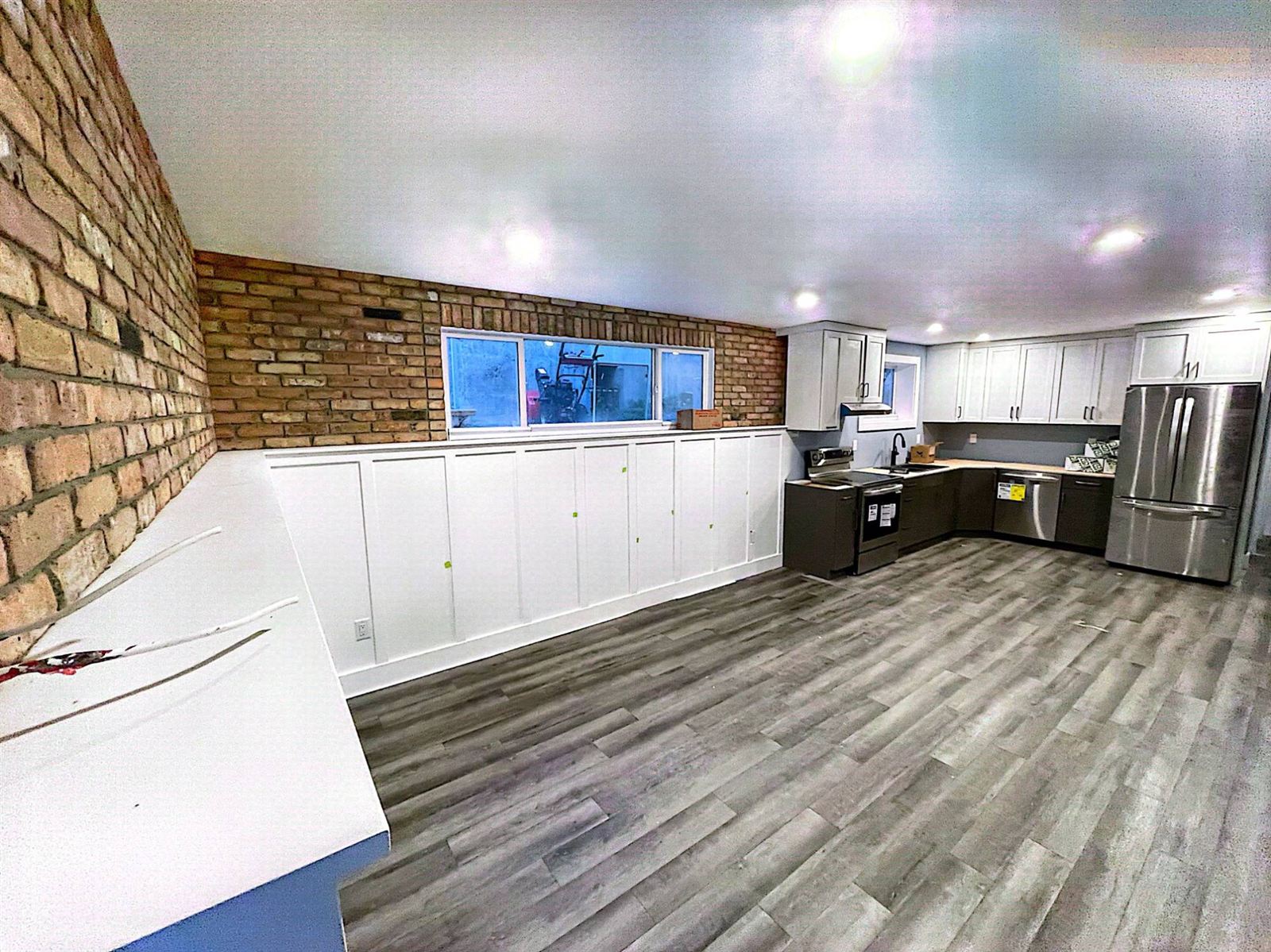 Basement suite with new kitchen, wainscoting and brick wall