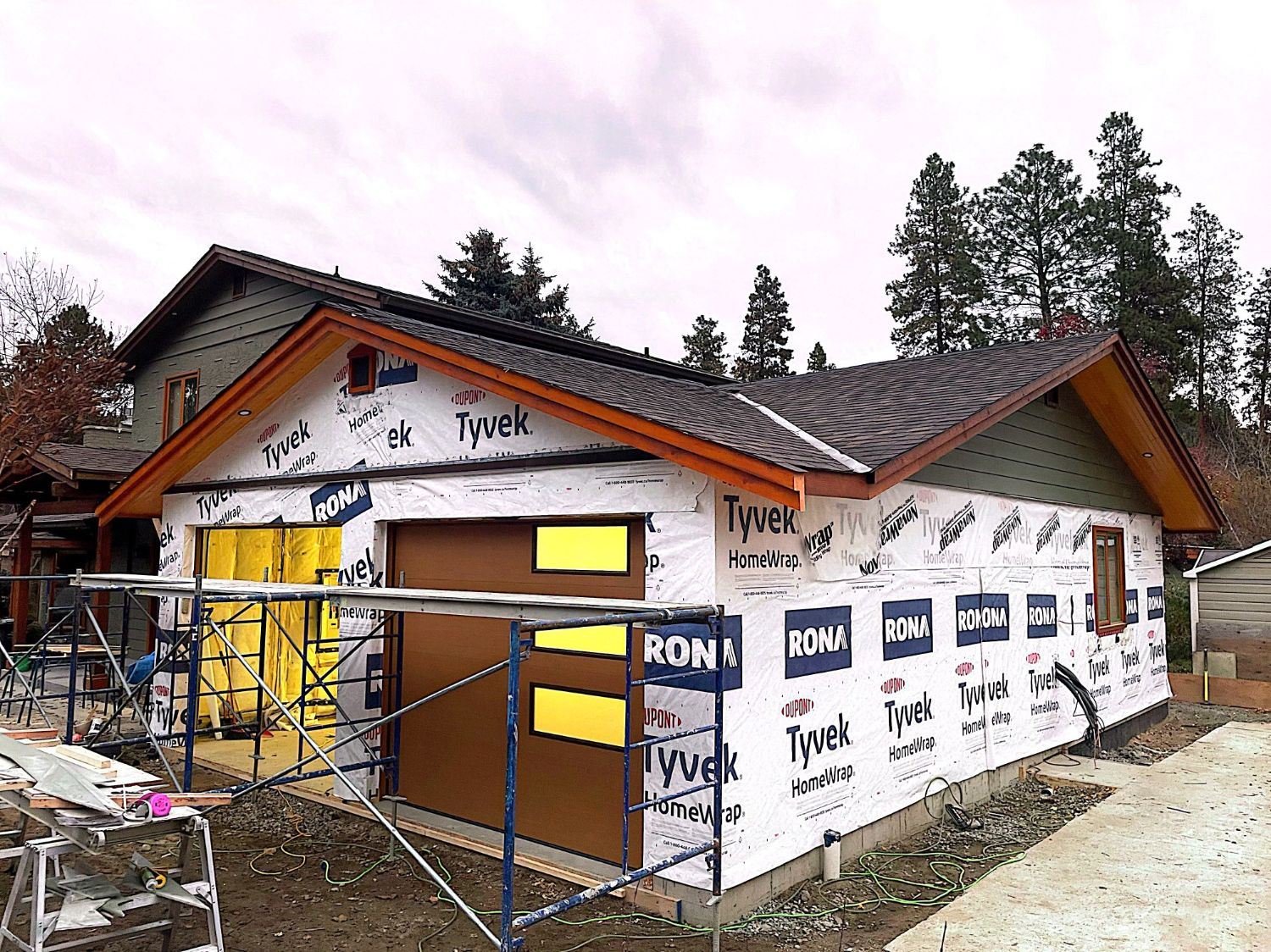 Garage addition under construction with roof on and building wrap