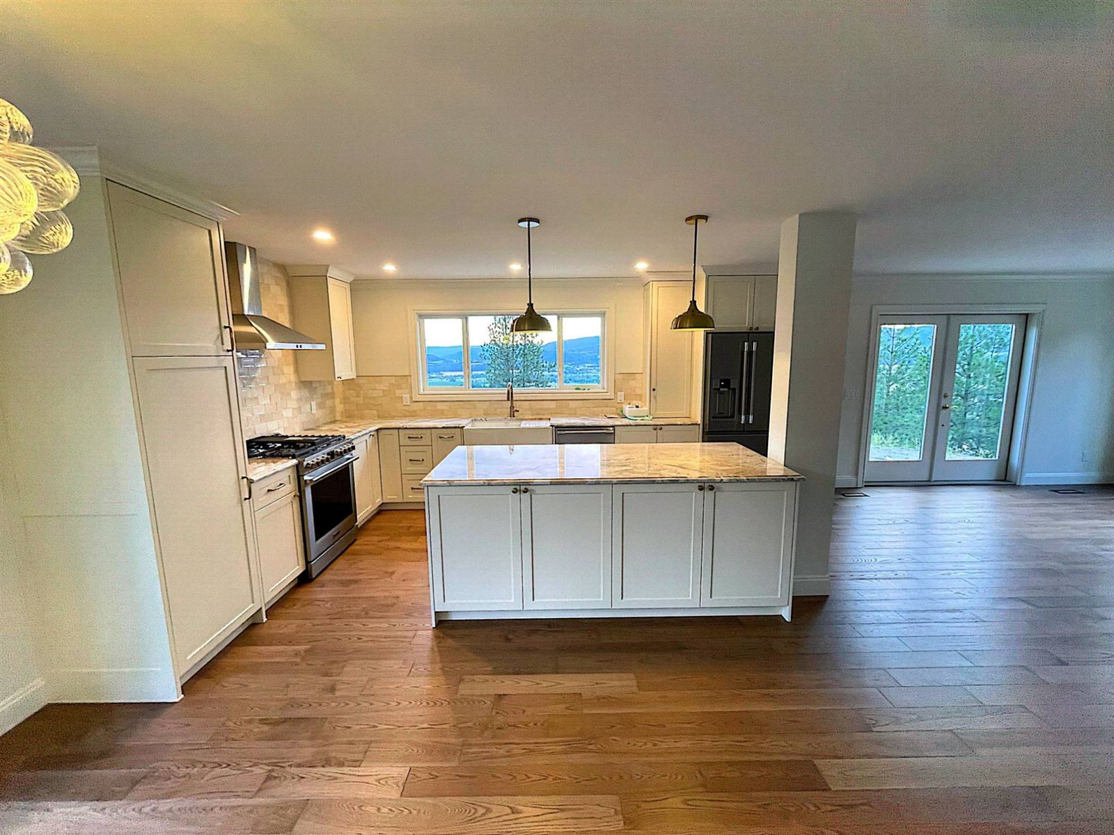 Open-concept kitchen with island, shaker cabinets and valley views